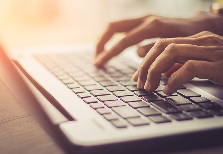 Hands typing on a keyboard