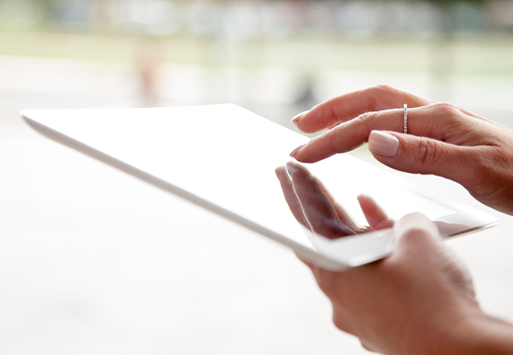Woman typing on tablet
