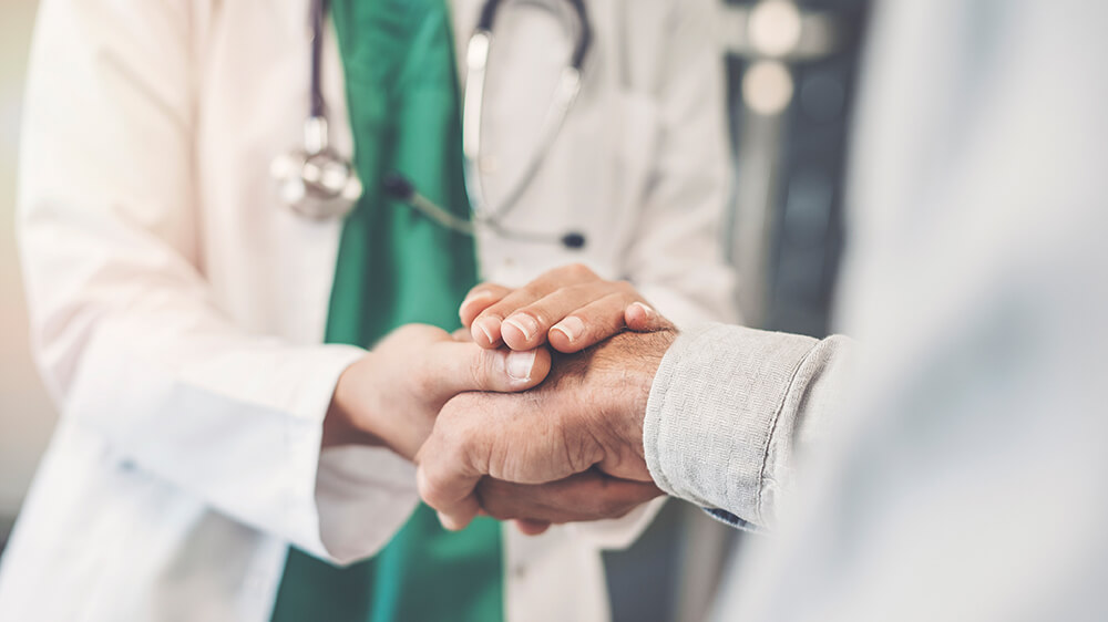Caring healthcare professional holding a patient's hand