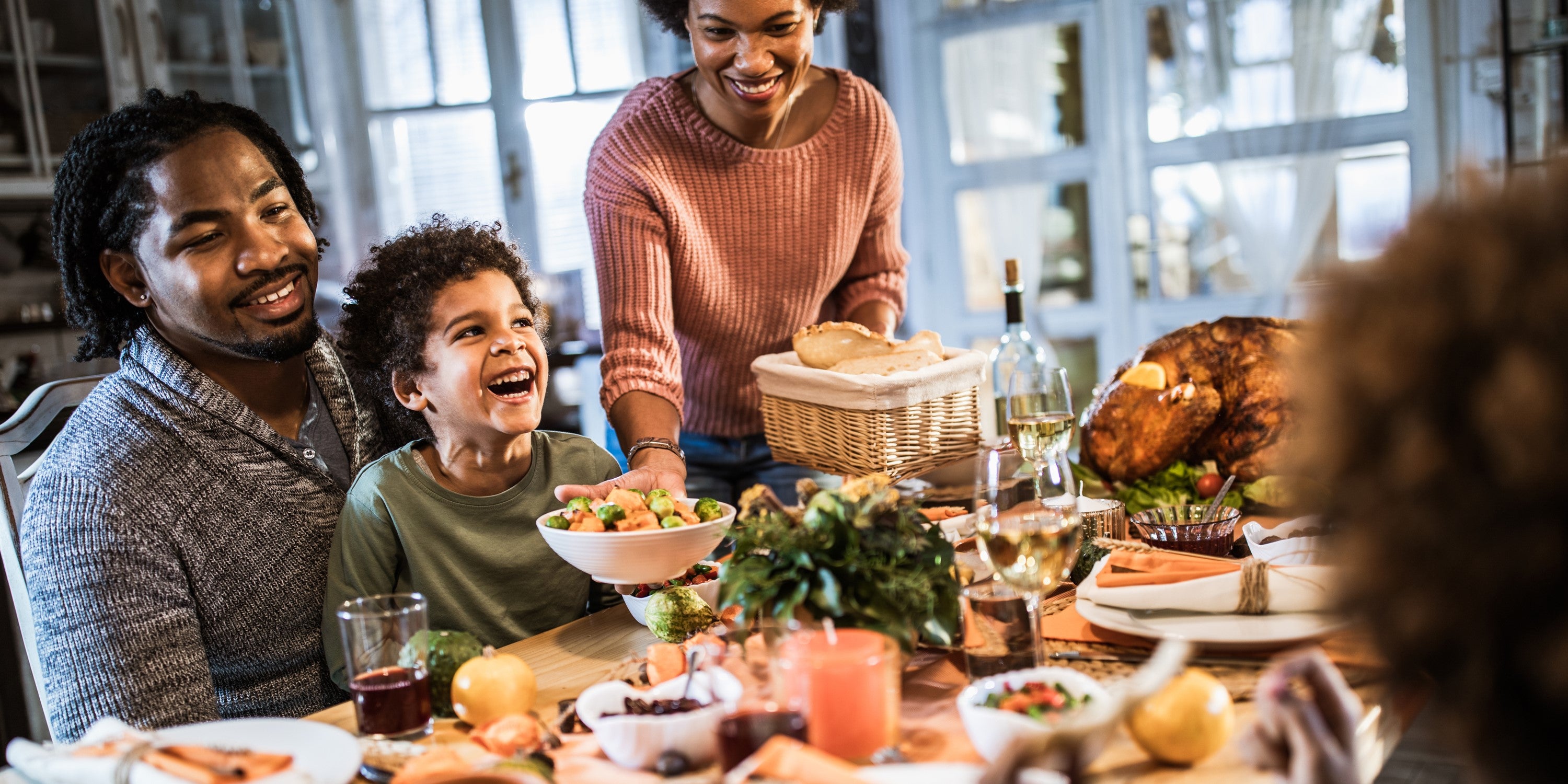 parents and child at dinner table laughing
